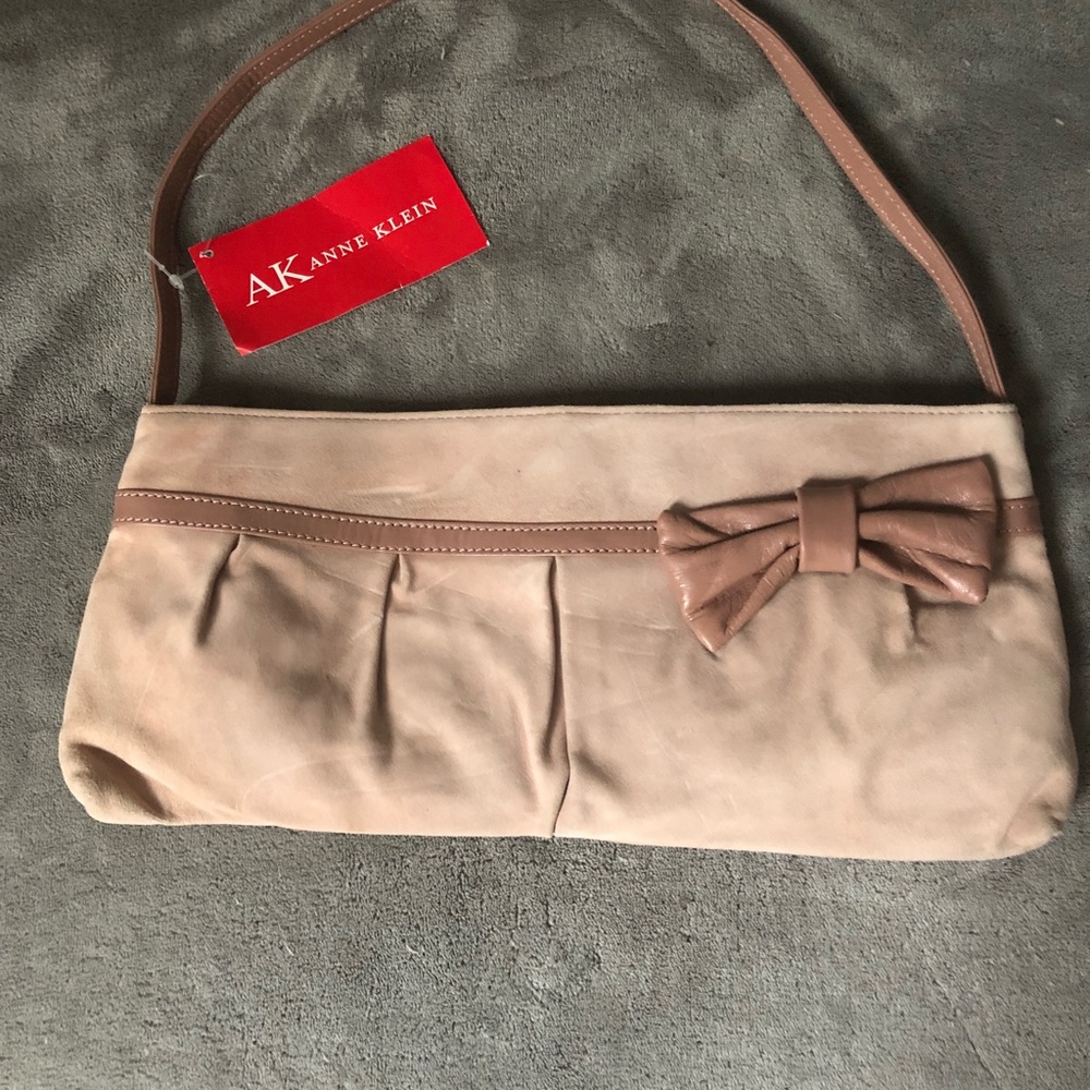 Pink suede clutch style purse with bow tie accent